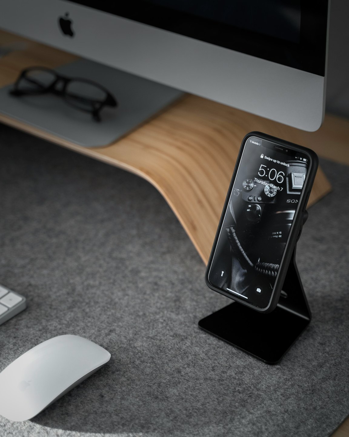 Smartphone on desk with wireless mouse and keyboard.